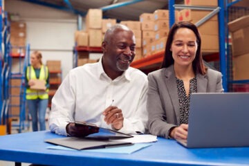 Homem e mulher frente ao notebook vendo software para a empresa