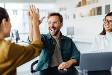 Homem e mulher batendo as mãos com sorriso no rosto