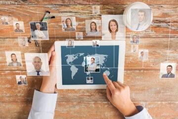 Mãos utilizando tablete para ver pessoas ao redor do mundo